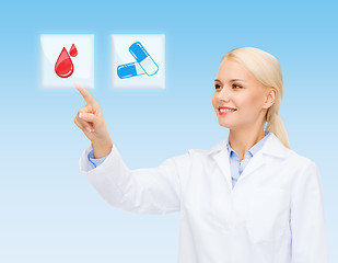 Image showing smiling doctor or nurse pointing to pills icon