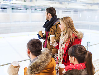 Image showing happy friends with coffee cups on skating rink