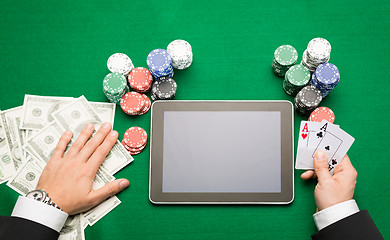 Image showing casino poker player with cards, tablet and chips