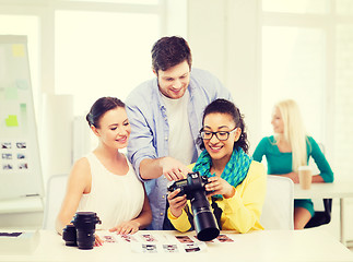 Image showing smiling team with photocamera working in office