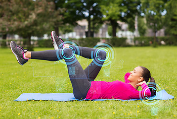 Image showing smiling woman doing exercises on mat outdoors