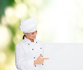 Image showing smiling female chef with white blank board