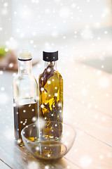 Image showing close up of two olive oil bottles and glass bowl