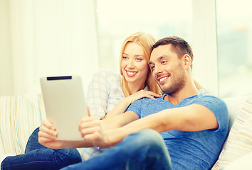 Image showing smiling happy couple with tablet pc at home