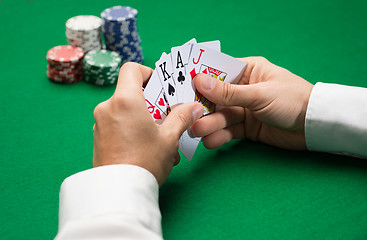 Image showing poker player with cards and chips at casino