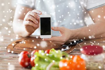 Image showing closeup of man showing smartphone in kitchen