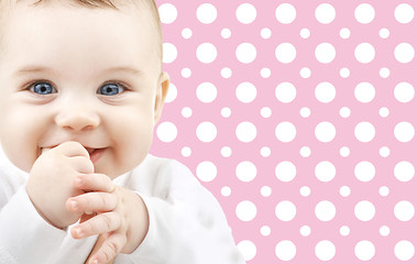 Image showing smiling baby girl face over pink polka dots