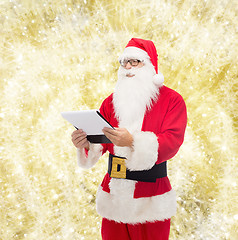 Image showing man in costume of santa claus with notepad