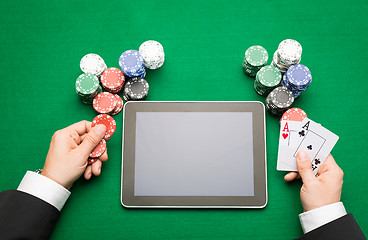 Image showing casino poker player with cards, tablet and chips