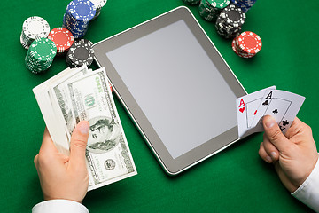 Image showing casino poker player with cards, tablet and chips