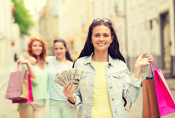 Image showing smiling teenage girls with shopping bags on street