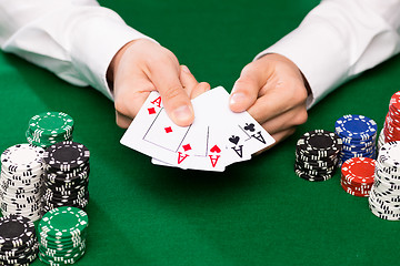 Image showing poker player with cards and chips at casino