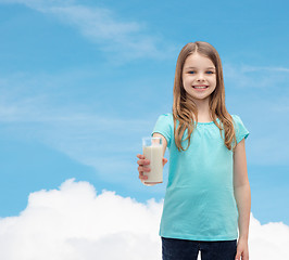 Image showing smiling little girl giving glass of milk