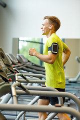 Image showing smiling man exercising on treadmill in gym