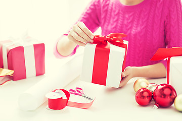 Image showing close up of woman decorating christmas presents