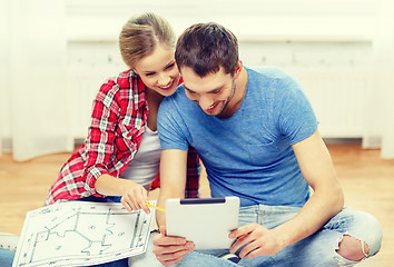 Image showing smiling couple looking at tablet pc at home