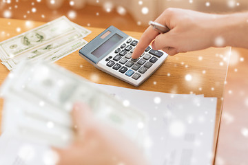 Image showing close up of man counting money and making notes