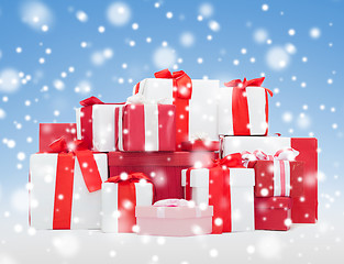 Image showing christmas presents over blue background with snow