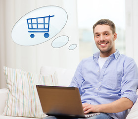 Image showing smiling man with laptop shopping online at home