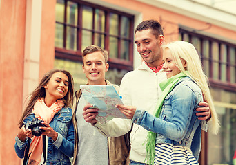 Image showing group of smiling friends with map and photocamera