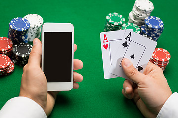 Image showing casino player with cards, smartphone and chips