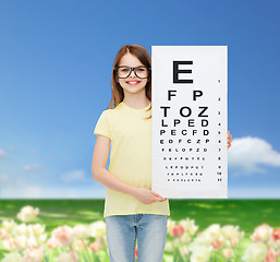 Image showing little girl in eyeglasses with eye checking chart