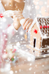 Image showing close up of woman making gingerbread house at home