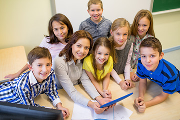 Image showing group of kids with teacher and tablet pc at school