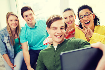 Image showing smiling students making selfie with tablet pc