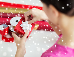 Image showing close up of woman decorating christmas present