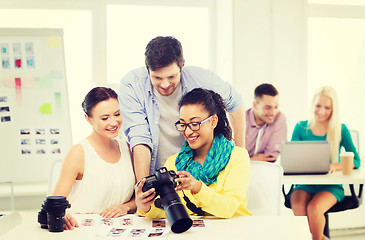 Image showing smiling team with photocamera working in office