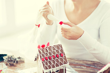 Image showing close up of woman making gingerbread houses