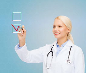 Image showing female doctor drawing mark to check box