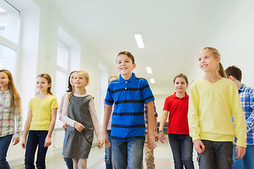 Image showing group of smiling school kids walking in corridor