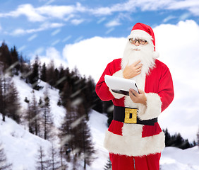 Image showing man in costume of santa claus with notepad