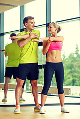 Image showing smiling man and woman exercising in gym