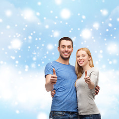 Image showing happy couple showing thumbs up and hugging