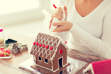Image showing close up of woman making gingerbread house at home