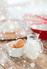 Image showing close up of milk jug, eggs, whisk and flour