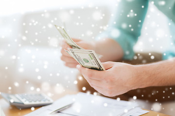 Image showing close up of man counting money and making notes