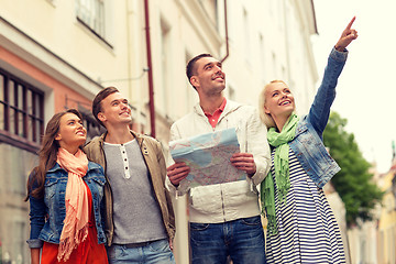 Image showing group of smiling friends with map exploring city