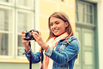 Image showing smiling girl with digiral photocamera in the city