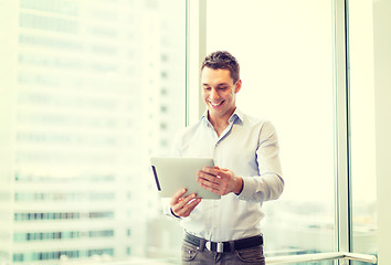 Image showing smiling businessman with tablet pc in office