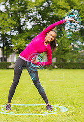 Image showing smiling woman stretching back outdoors