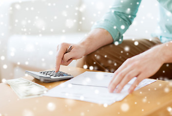 Image showing close up of man counting money and making notes