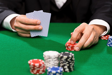 Image showing poker player with cards and chips at casino