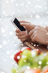 Image showing close up of man showing smartphone in kitchen