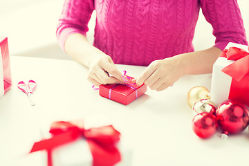 Image showing close up of woman decorating christmas presents