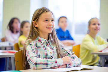 Image showing group of school kids with notebooks in classroom