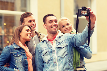 Image showing group of smiling friends making selfie outdoors